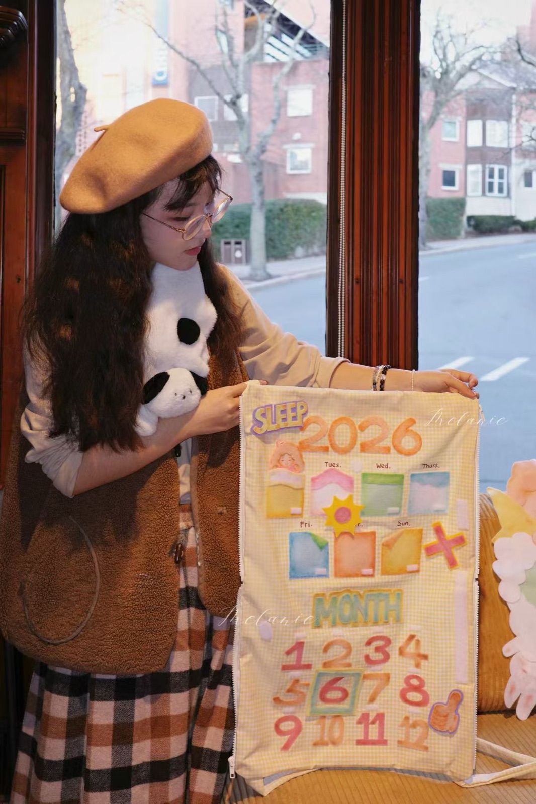 Simei Liang holding her Sleep Through 2026 calendar